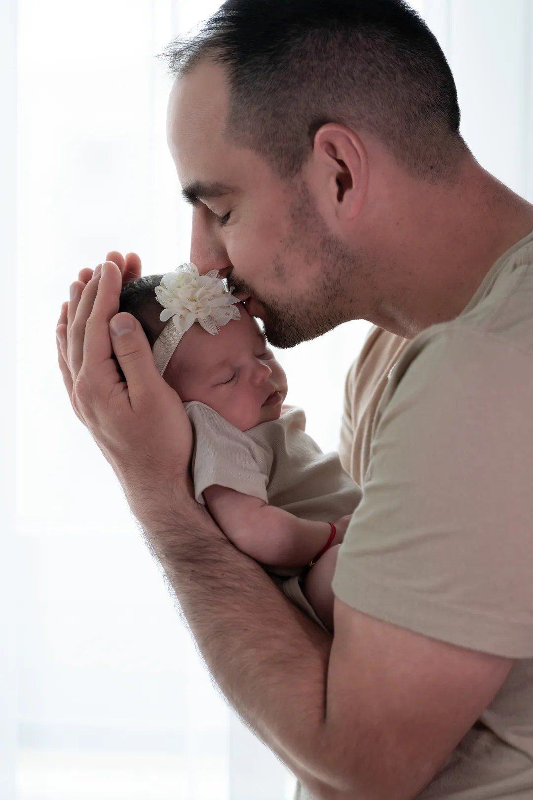 Foto eines Mannes, der sein Baby an der Stirn küsst