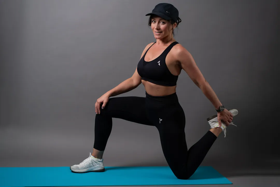 Porträt einer Frau in sportlicher Bekleidung beim Üben auf Yoga-Matte